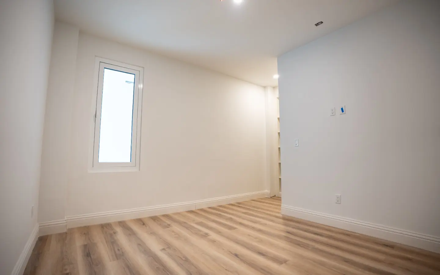 Primary bedroom at Casa Playa 315 with ceiling-cassette air conditioning and wood-look flooring