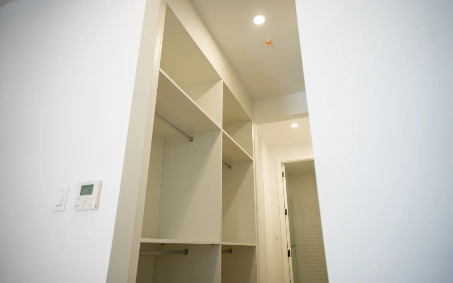 Detail of the built-in closet shelving and hanging rails beside the climate control panel