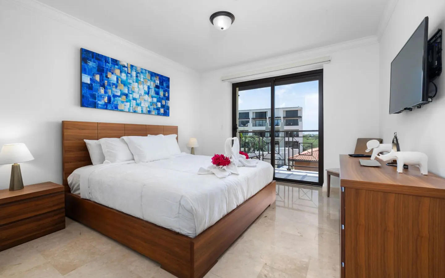 Second bedroom with a king bed, wall art and its own sliding door to the balcony