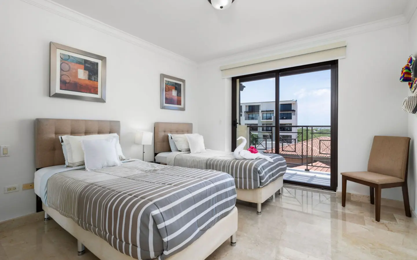 Third bedroom seen from the doorway, with a wall-mounted TV and the balcony beyond