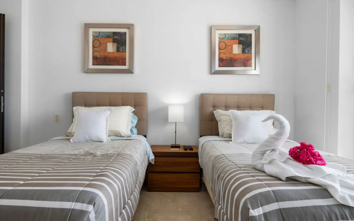 Twin beds with framed artwork and a shared nightstand in the third bedroom