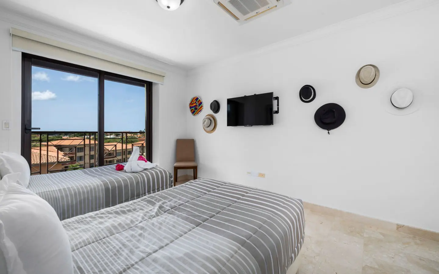 Third bedroom with two twin beds and direct balcony access in the Palm Beach condo