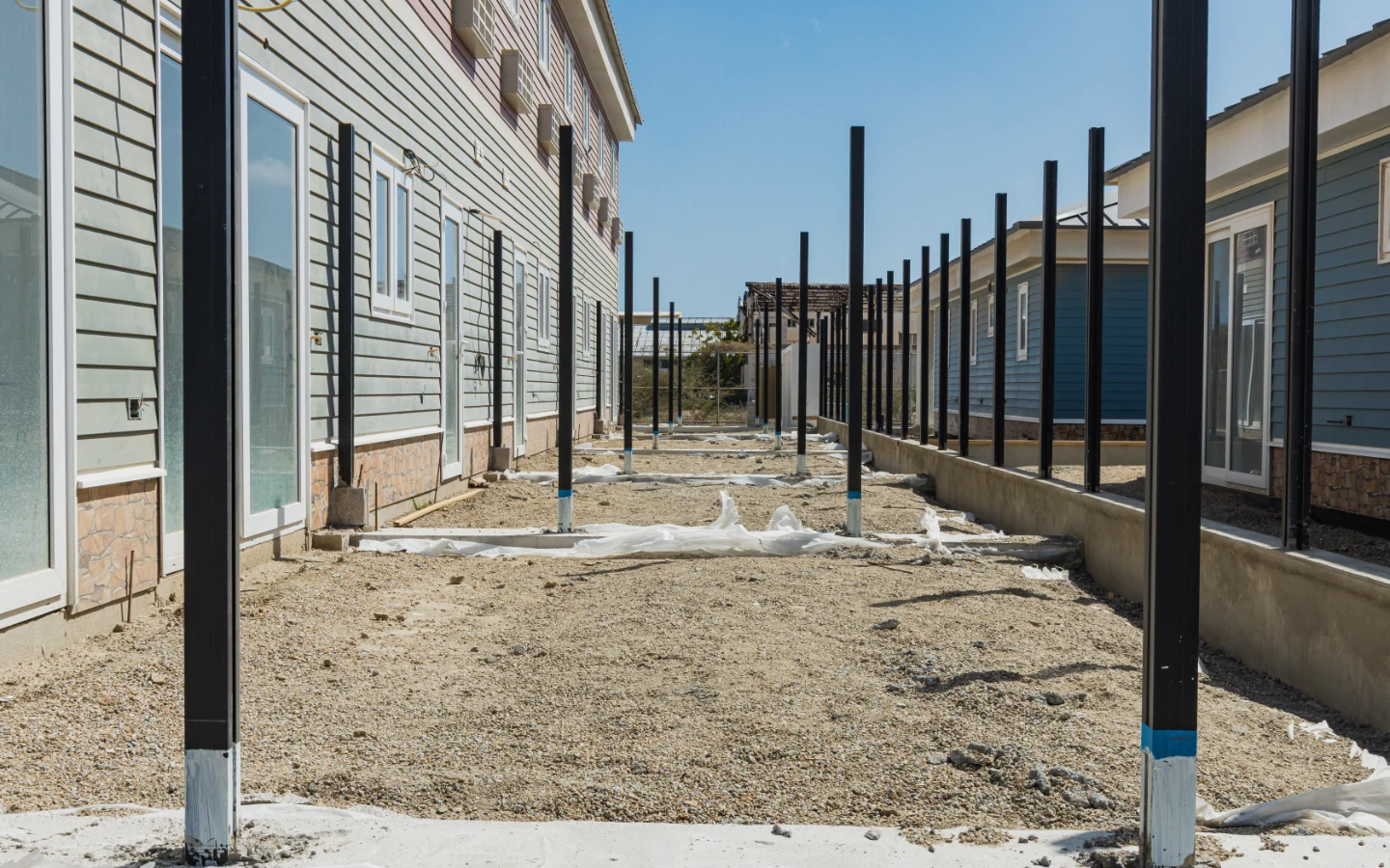 Row of villas at Caribbean Town with standing metal structures for fence separation in progress