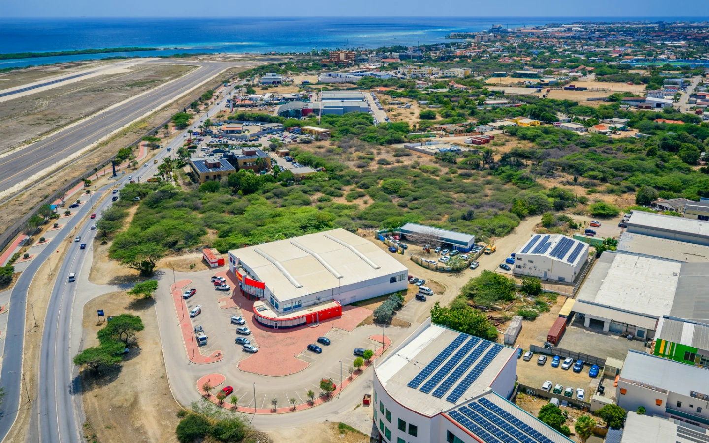 The flat Camacuri parcel next to the Do it Best warehouse and neighboring commercial buildings