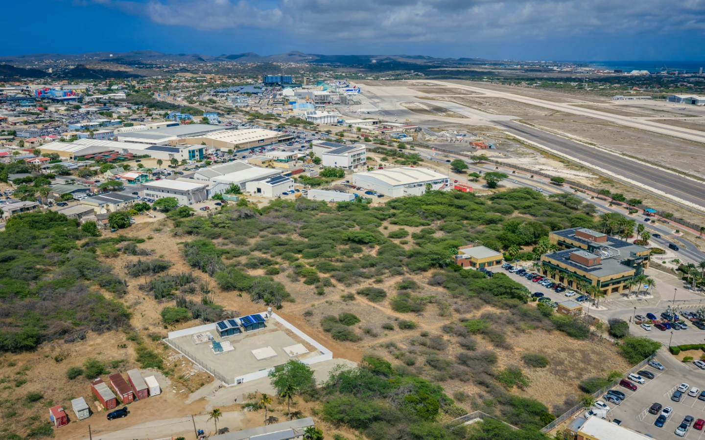 Aerial of the parcel with the airport terminal and aircraft on stand visible along the corridor
